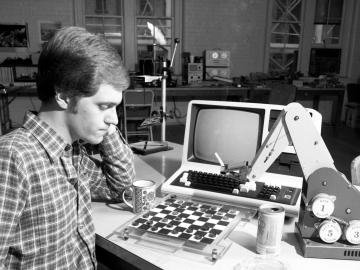 A researcher plays checkers against an AI-powered robotic arm in 1984. Credit: ORNL, U.S. Dept. of Energy