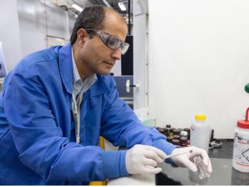 Caption: Jaswinder Sharma makes battery coin cells with a lightweight current collector made of thin layers of aligned carbon fibers in a polymer with carbon nanotubes. Credit: Genevieve Martin/ORNL, U.S. Dept. of Energy