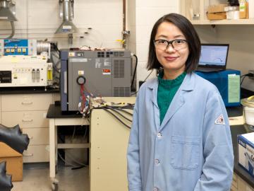 Chelsea Chen, polymer physicist at ORNL, stands in front of an eight-channel potentiostat and temperature chamber used for battery and electrochemical testing. Credit: Genevieve Martin/ORNL, U.S. Dept. of Energy