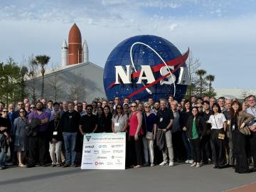 SOS26 attendees standing in front of the Kennedy Space Center on Merrit Island, Florida the night of their dinner reception provided by the conference sponsors. The keynote speaker was Rupak Biswas from NASA. Credit: Judy Potok/ORNL, U.S. Dept. of Energy