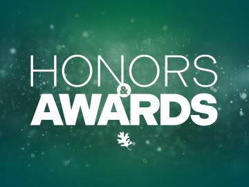 Honors & Awards in white with a green background with an oak leaf underneath