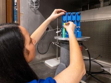 woman places lithium-ion battery in test chamber