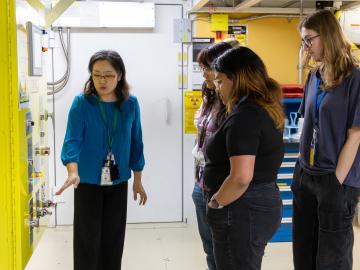 Students listen as ORNL instrument scientist Hanyu Wang explains the intricacies of the LIQREF instrument at the Spallation Neutron Source