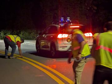 Researchers from ORNL and Western Michigan University prepare for a Chattanooga-based demonstration of a self-driving car using chip-enabled raised pavement markers for navigation.