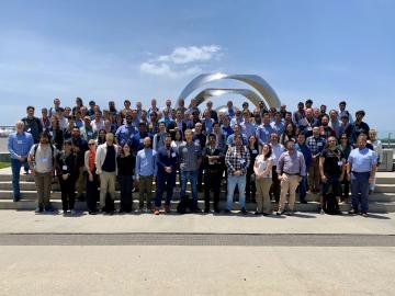 Large group photo outside on stairs at the Quantum Science Center all hands meeting.