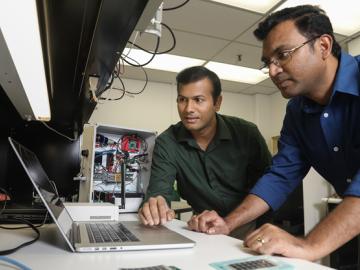 ORNL researchers Gautam Thakur (left) and Teja Kuruganti demonstrate UrbanSense, a novel sensor network aimed at helping cities manage their growth and evaluate future development opportunities. The platform collects open-source population, traffic and en