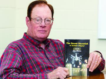 ORNL retiree Jim Ealy with his book “The Secret Revealed . . . A Nuclear Odyssey.” (ORNL Photo by Carlos Jones) 