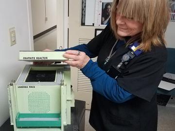 Deb Austin lifts the top of the Graphite Reactor model. Deb Austin lifts the top of the Graphite Reactor model.