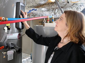 ORNL researcher Heather Buckberry adjusts settings on a home appliance. Smart appliances and heating/cooling systems are designed to give homeowners the ability to closely manage electricity usage. ORNL researcher Heather Buckberry adjusts settings on a home appliance. Smart appliances and heating/cooling systems are designed to give homeowners the ability to closely manage electricity usage.