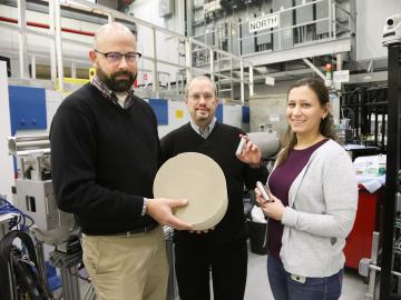 ORNL researchers Todd Toops, Charles Finney, and Melanie DeBusk (left to right) hold an example of a particulate filter used to collect harmful emissions in vehicles. 