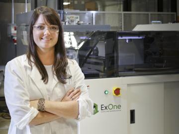 Researcher Amy Elliott and the ExOne binder jet printer at the Manufacturing Demonstration Facility.