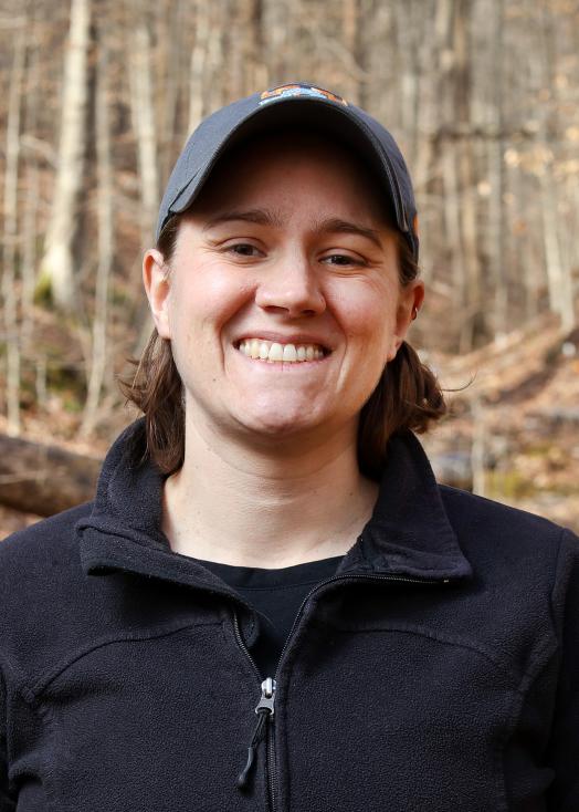 ORNL researcher Natalie Griffiths by a forest stream in the fall
