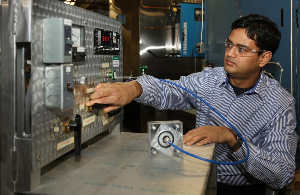 ORNL researcher Kaushik Biswas demonstrates how a self-healing barrier in a vacuum insulation panel can recover from a puncture.