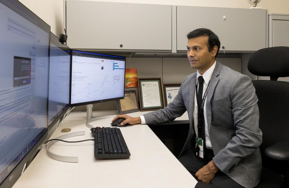 Researcher Gautam Thakur works at his desk.