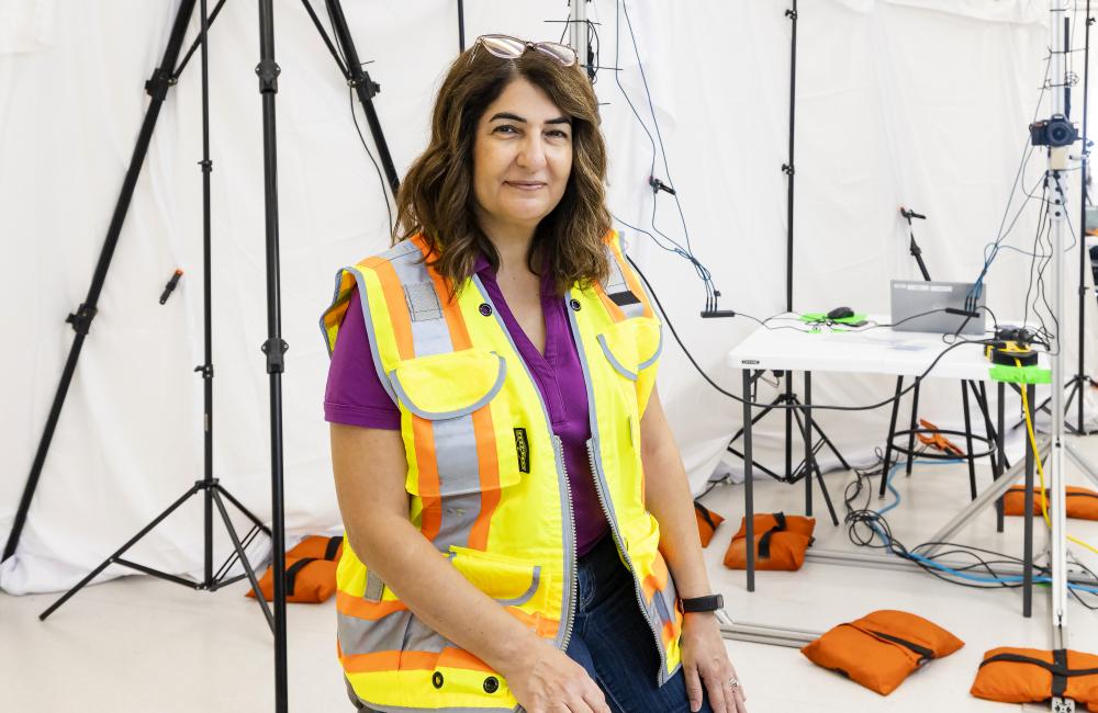 woman in yellow emergency vest sitting in front of camera and sensing equipment