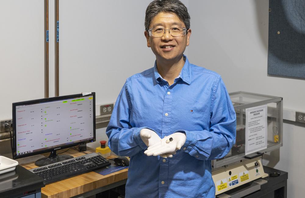 Jun Qu of ORNL shows stainless-steel disks