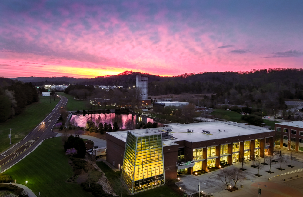 The sun rises behind the ORNL Visitor Center in this aerial photo from April 2023. Credit: Kase Clapp/ORNL, U.S. Dept. of Energy