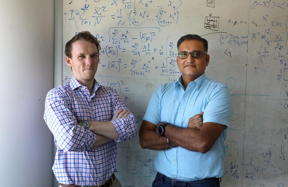 Rajeev Kumar, ORNL Research Scientist, with Dustin Eby, ORISE student, working formulas on white board at CNMS