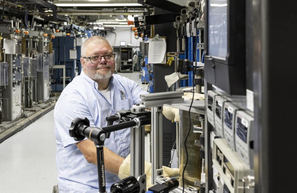 Jeremy Moser, a technician at the Physical Sciences Directorate, poses in the testing laboratory where he studies how materials react under extreme pressure.