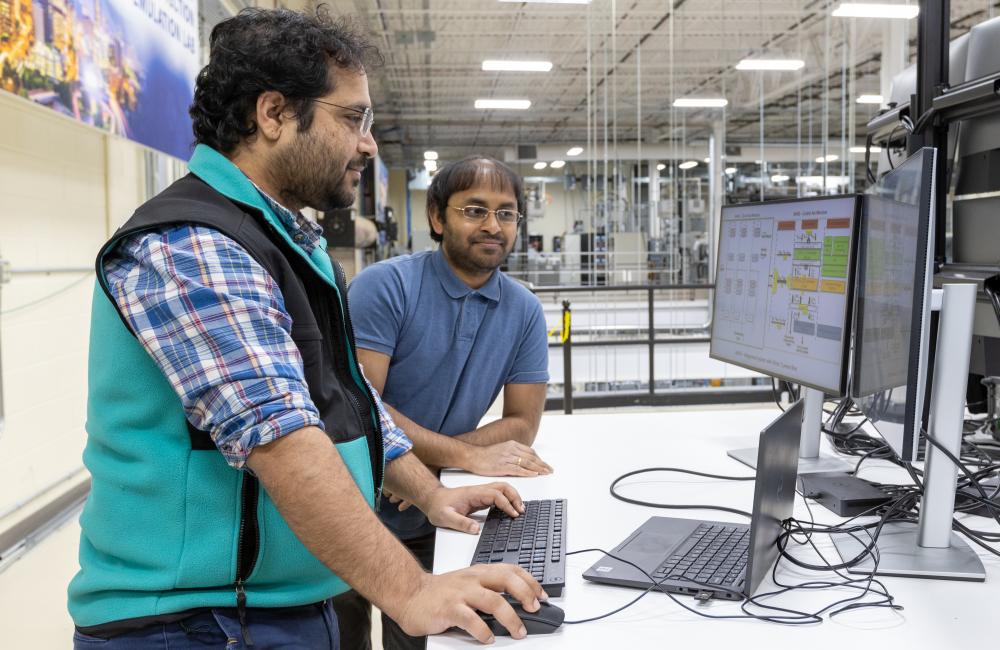 ORNL researchers Phani Marthi and Suman Debnath work on developing and scaling up new EMT simulation software to analyze how power electronics in the electric grid will respond to brief interruptions in power flow. Credit: Genevieve Martin/ORNL, U.S. Dept. of Energy