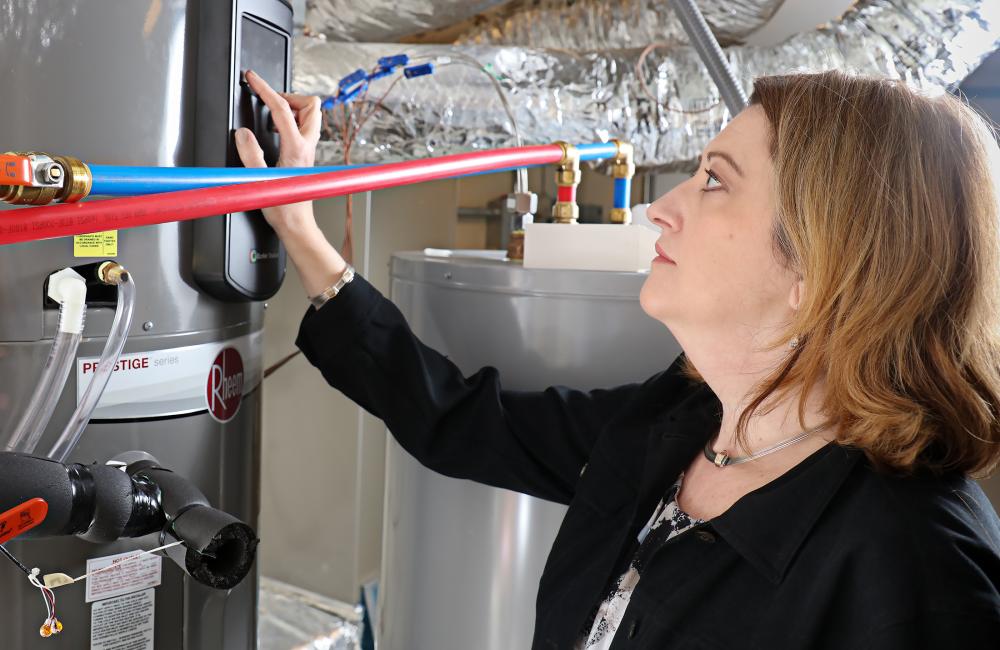 ORNL researcher Heather Buckberry adjusts settings on a home appliance. Smart appliances and heating/cooling systems are designed to give homeowners the ability to closely manage electricity usage. 