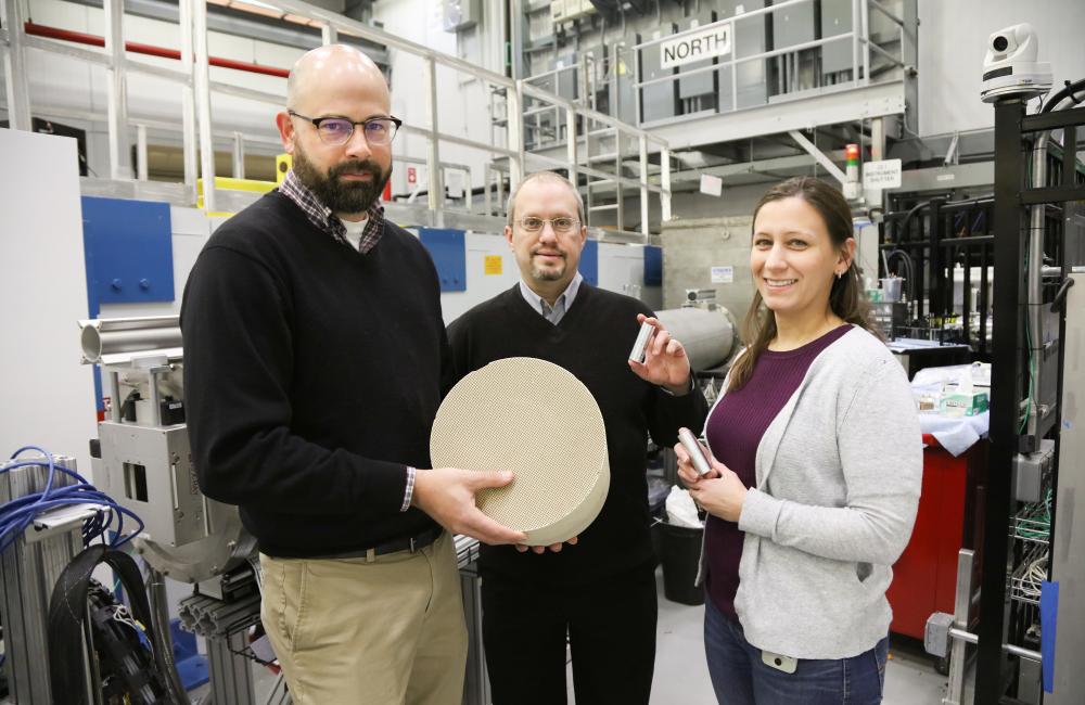 ORNL researchers Todd Toops, Charles Finney, and Melanie DeBusk (left to right) hold an example of a particulate filter used to collect harmful emissions in vehicles. 