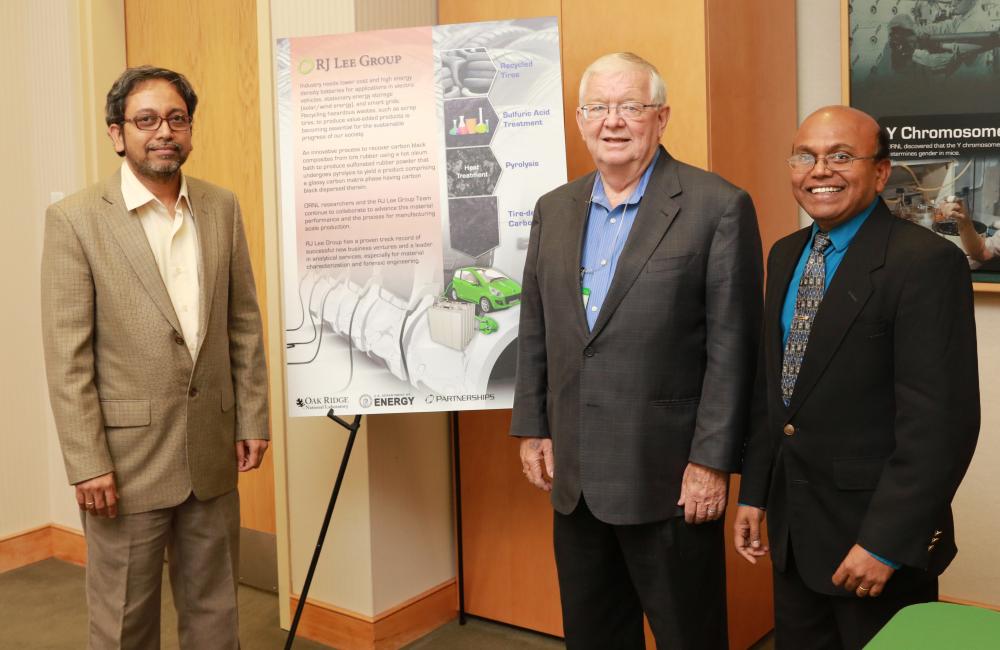 An ORNL technology that converts waste rubber into a valuable energy storage material has been licensed to RJ Lee Group. ORNL inventors Amit Naskar (left) and Parans Paranthaman flank Richard Lee, CEO of RJ Lee Group. 