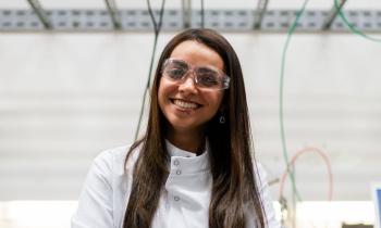 Young woman in lab coat standing in front of lab bench