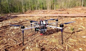 A Strelka Artemis drone sits on the floor of a wooded area
