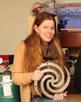 Portrait of Kiersten holding spiral pole piece from the Maryland 2 MeV Cyclotron