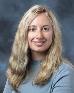 Erin Drufva headshot against blue and gray background