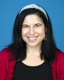 Profile image of Angela Gosnell wearing a red sweater and black shirt and blue headband.